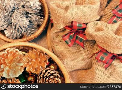 Xmas gift and pine cone in basket, decoration for christmas season, present bag from burlap, with amazing knot