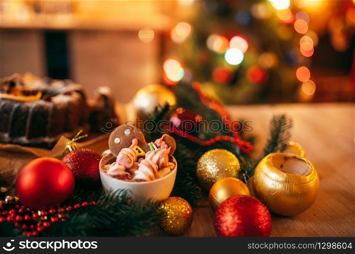 Xmas gingerbread man, holiday dessert closeup. Christmas traditional symbol, festive sweet food, fir tree branch, red balls. Xmas gingerbread man, holiday dessert closeup