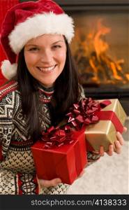 Xmas present happy woman by home fireplace wear Santa hat