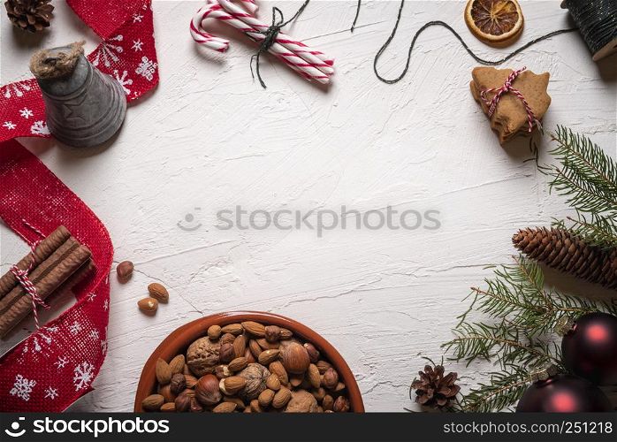 Xmas tabletop with many traditional sweet food and decorations. Walnuts, and almonds in a plate and gingerbread cookies