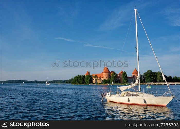 Yacht boats and Trakai Island Castle in lake Galve in day, Lithuania. Trakai Castle is one of major tourist attractions of Lituania. Trakai Island Castle in lake Galve, Lithuania