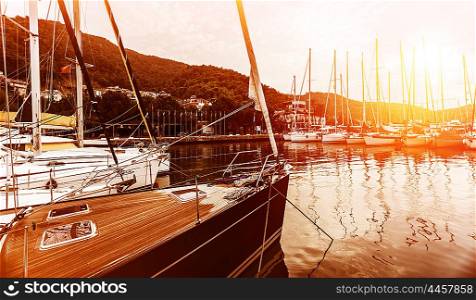 Yacht harbor on sunset, calm bay, beautiful landscape, luxury lifestyle, marina on orange sunrise, water transport, summer vacation concept