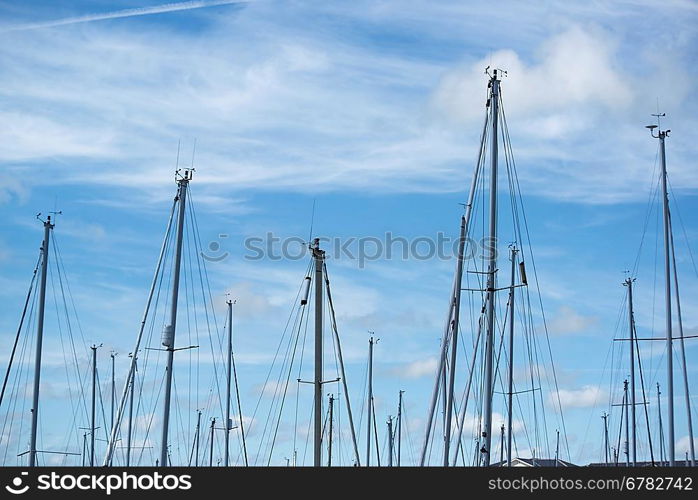 Yacht masts against blue Summer sky