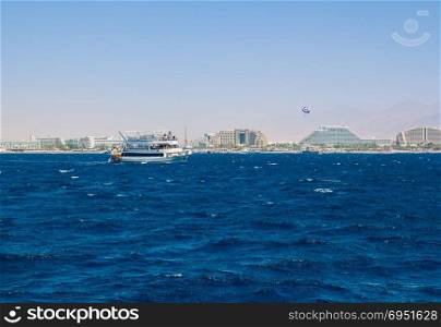 Yacht sailing in the Red Sea. In the background the hotel strip of Eilat.