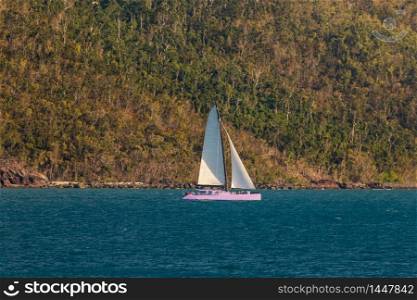 Yacht sailing next to a tropical island