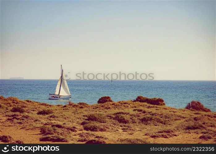 Yachting on sail boat during sunny summer weather on calm blue sea water. Yacht sailing on sea water
