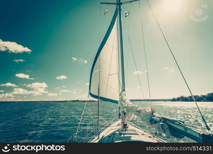 Yachting on sail boat during sunny summer weather on calm blue sea water. Sporty transportation conept.. Yachting on sail boat during sunny weather