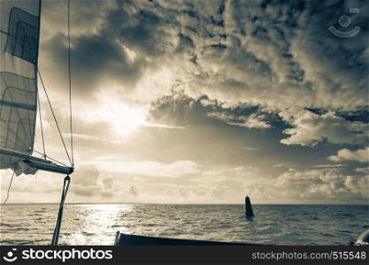 Yachting on sail boat during sunny summer weather on calm sea water. Sporty transportation concept.. Yachting on sail boat during sunny dark weather