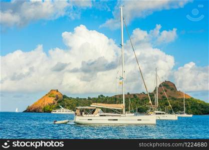 Yachts anchored at the Pigeon Island with fort ruin on the rock, Rodney bay, Saint Lucia, Caribbean sea
