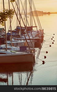 Yachts and boats moored in a harbour at sunrise. Candid people, real moments, authentic situations