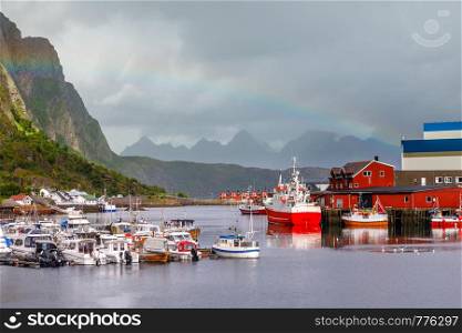 Yachts and boats with mountain in the background and rainbow arc at pier in Svolvaer, Lototen islands, Austvagoya, Vagan Municipality, Nordland County, Norway