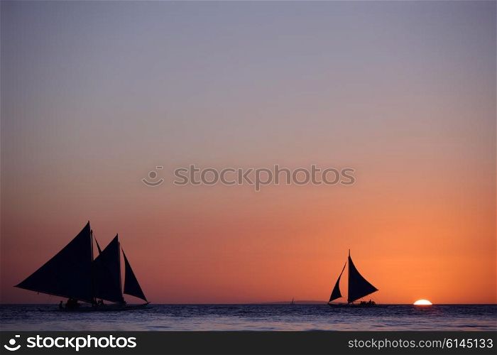 Yachts at sunset. Yachts sailing in tropical sea at sunset