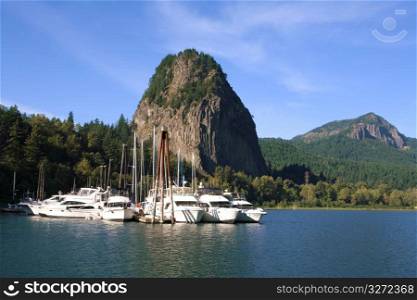 Yachts mooring at dock in remote area with rock formation in background