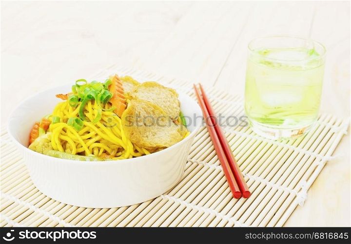 Yakisoba with chopstick and hand over bamboo pad