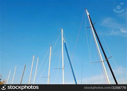 yatchs masts line up along the marina