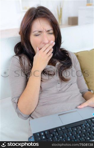 yawing woman on sofa yawning