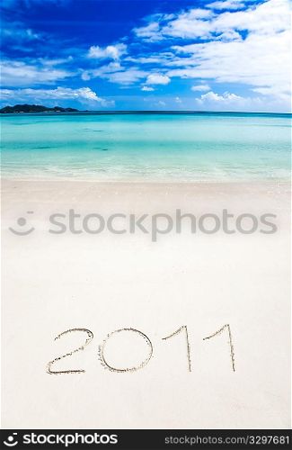 Year 2011 (two thousand and eleven) writenn in the sand of a tropical beach