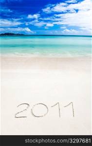 Year 2011 (two thousand and eleven) writenn in the sand of a tropical beach