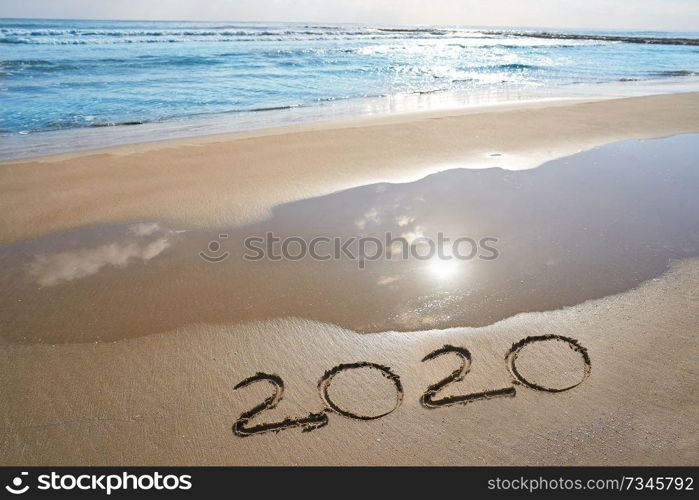 year 2020 numbers spell written on beach sand shore