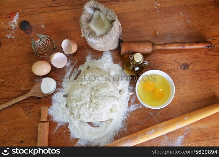 yeast dough, eggs and flour on wooden background
