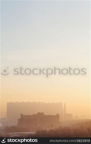 yellow and blue sunrise sky over urban houses in cold winter morning