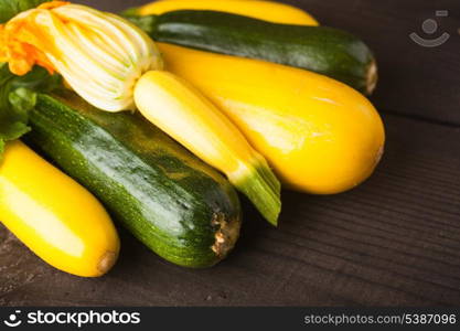 Yellow and green zucchini on the wood background