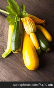 Yellow and green zucchini on the wood background