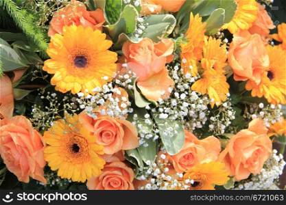 yellow and orange gerberas and roses in a floral arrangement