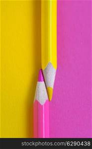 yellow and pink crayons on the same paper background