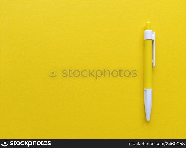 Yellow and white pen on yellow background. Minimalistic flat lay with copy space. Stock photography.. Yellow and white pen on yellow background. Minimalistic flat lay with copy space. Stock photo.
