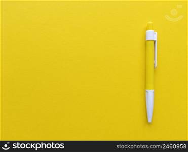 Yellow and white pen on yellow background. Minimalistic flat lay with copy space. Stock photography.. Yellow and white pen on yellow background. Minimalistic flat lay with copy space. Stock photo.