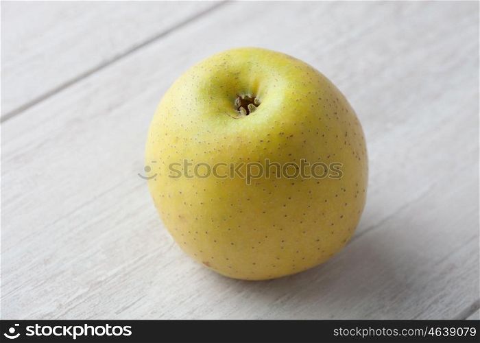 Yellow apple on a background of gray wood