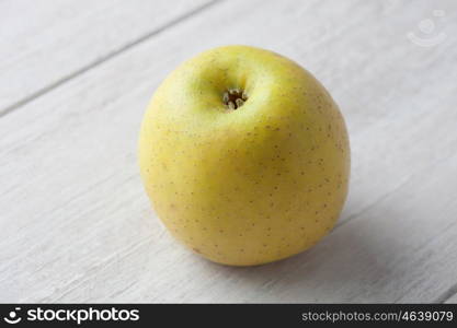 Yellow apple on a background of gray wood