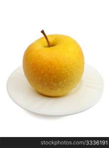 Yellow apple on a white plate on a white background, isolated