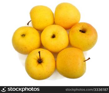 Yellow apples on a white plate on a white background, isolated