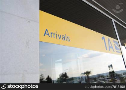 Yellow arrivals sign on outside of an airport
