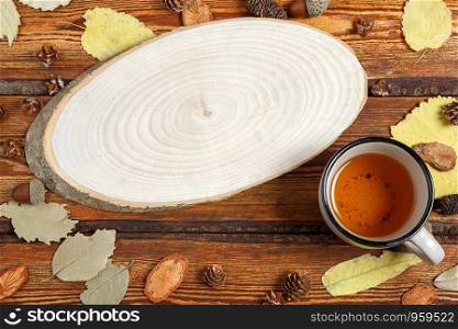 yellow autumn leaves and a glass of tea on a dark old wooden background with a blank space for text. top view. flat lay