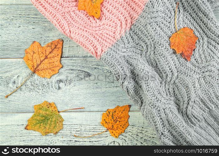 yellow autumn leaves on an old textured wooden background with a textured jacket