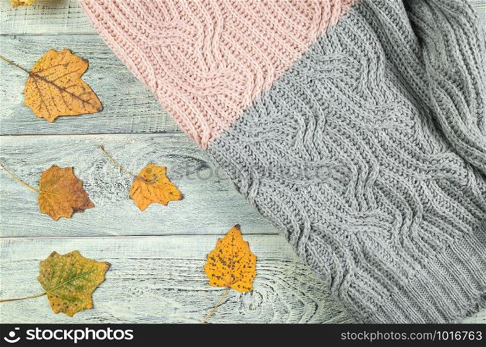 yellow autumn leaves on an old textured wooden background with a textured jacket