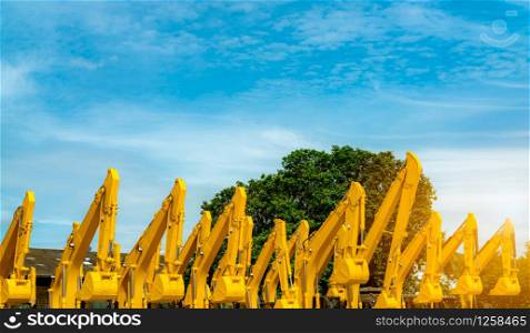 Yellow backhoe with hydraulic piston arm. Huge metal bulldozer. Excavator machine. Hydraulic machinery. Heavy machine industry. Mechanical engineering. Stock of backhoe at factory parking lot.