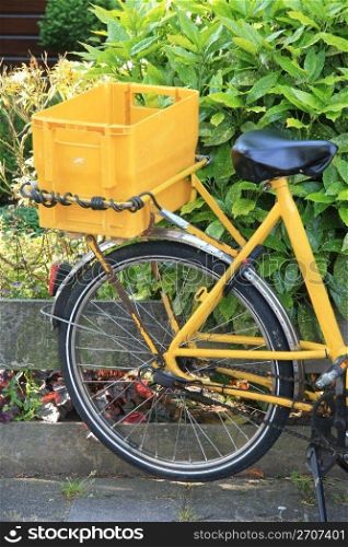 Yellow bike with a container, used to transport the daily mail and small packages
