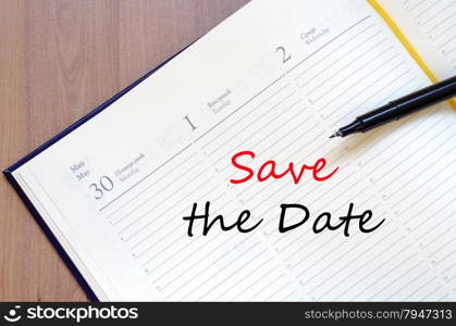 Yellow blank notepad on office wooden table Save the date concept