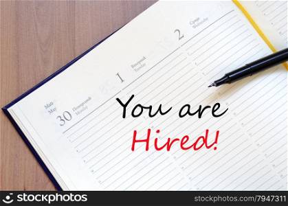 Yellow blank notepad on office wooden table You are hired concept