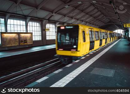 Yellow blurred subway train in Berlin. Public U-bahn transport in underground station interior