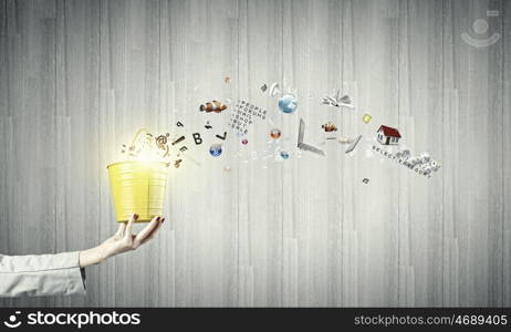 Yellow bucket with icons. Close up of businesswoman hand holding bucket with icons