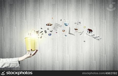 Yellow bucket with icons. Close up of businesswoman hand holding bucket with icons