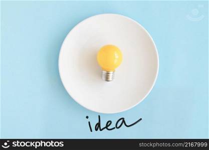 yellow bulb white plate with idea text blue background