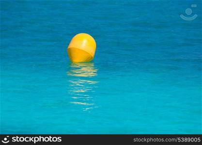 Yellow buoy floating in balearic turquoise Mediterranean sea