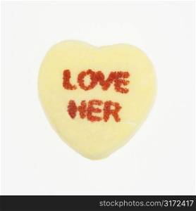 Yellow candy heart that reads love her against white background.