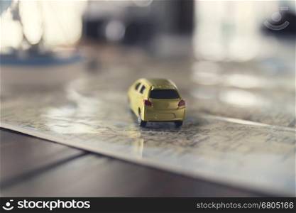 yellow car figurine on map for trip vacation traveling concept, selected focus and vintage tone